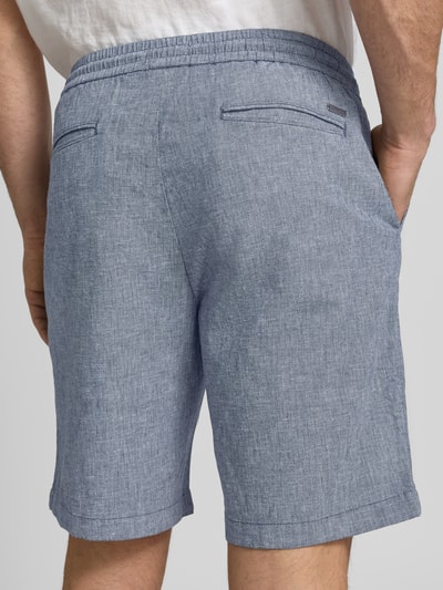 Männermodel trägt Bermudas mit französischen Eingrifftaschen Modell 'COLI' von Fynch-Hatton, blauer Baumwoll-Mix mit Leinen, lockere Passform, feine Webstruktur, elastischer Bund mit Kordelzug, Gesäßleistentaschen, Ganzkörperansicht Rückansicht.
