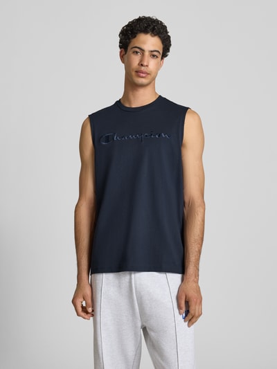 Männermodel trägt Top mit Label-Stitching und Rundhalsausschnitt von CHAMPION in Dunkelblau, Reine Baumwolle, Regular-Fit, Ganzkörperansicht von vorne. Rückenlänge bei Größe M: 71 cm.