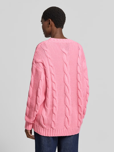 Vrouwenmodel draagt cardigan met motiefstitchings en v-hals van Milano Italy, katoenmix, loose fit, ruglengte maat S 74 cm, mouwlengte 57 cm, geheel in roze kabelstructuur, achterkant, geheellichaamsfoto