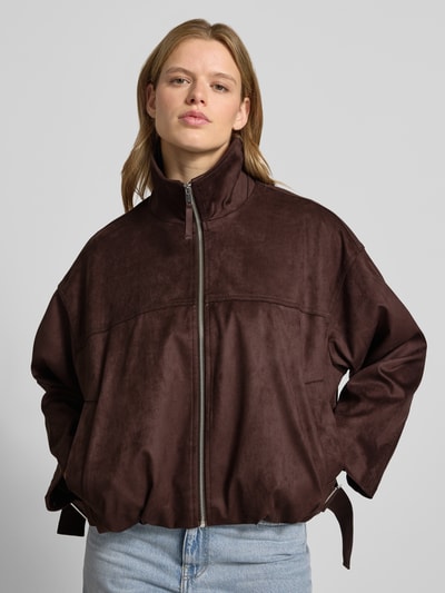 Frauenmodel trägt Jacke in Leder-Optik mit Reißverschluss und Eingrifftaschen von Gina Tricot, braun, Relaxed-Fit, Material-Mix mit Stretch-Anteil, Nahaufnahme Oberkörper.