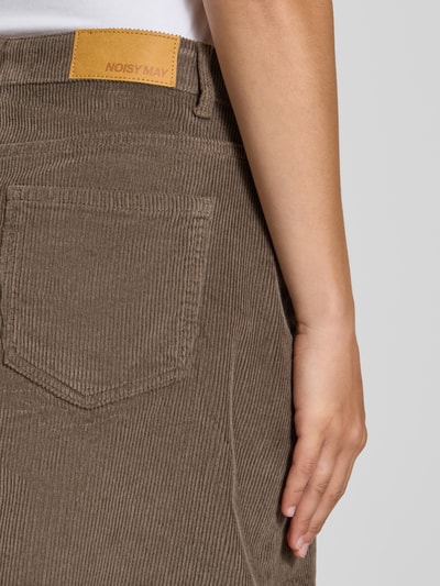 Frauenmodel trägt Minirock aus Baumwoll-Mix in Cord-Optik von NOISY MAY®, braune Struktur, sichtbare Gesäßtasche, Nahaufnahme Rückansicht.
