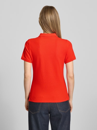Frauenmodel trägt Slim Fit Poloshirt mit Label-Stitching von Gant, Baumwoll-Elasthan-Mix, Knopfleiste, Rückenlänge 59 cm, Ganzkörperansicht Rückansicht.