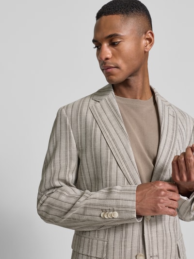 Męski model nosi Slim Fit 2-Knopf-Sakko mit Pattentaschen Modell 'CIDATA' von CINQUE, materiał z domieszką wełny, beżowo-czarne paski, krój slim fit, klapy, kieszenie z patkami, długość tyłu 76 cm, szerokość ramion 42 cm, długość rękawa 64 cm, ujęcie z przodu, zbliżenie na górną część ciała.