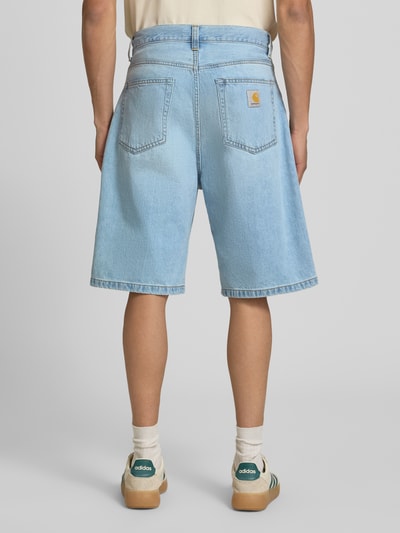 Männermodel trägt Jeansshorts mit Eingrifftaschen Modell 'Robertson' von Carhartt Work In Progress in Hellblau, Relaxed-Fit, Reine Baumwolle, Ganzkörperansicht Rückansicht. Bundweite 47 cm, Innenbeinlänge 28 cm bei Größe 32.