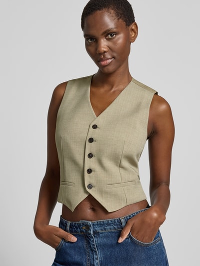 Frauenmodel trägt Slim Fit Weste mit V-Ausschnitt von Iro aus reiner Baumwolle, Knopfleiste und Paspeltaschen, Nahaufnahme Oberkörper.