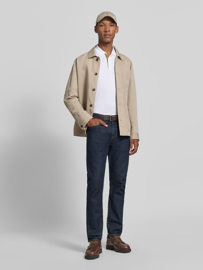 Männermodel trägt slim fit poloshirt uit puur katoen van Polo Ralph Lauren in wit, gecombineerd met blauwe jeans, ganzlichaamsvooraanzicht.