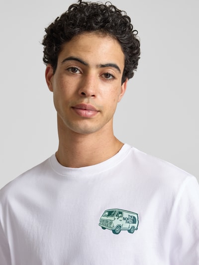 Männermodel trägt T-Shirt mit Label-Print und Rundhalsausschnitt von The North Face in Weiß, reine Baumwolle, Regular Fit, Nahaufnahme Oberkörper.