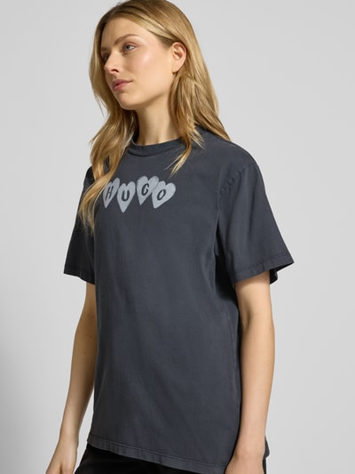 Frauenmodel trägt Regular Fit T-Shirt aus reiner Baumwolle Modell 'VINTAGE TEE_22' von HUGO in Unifarben mit Label Print, Nahaufnahme Oberkörper.