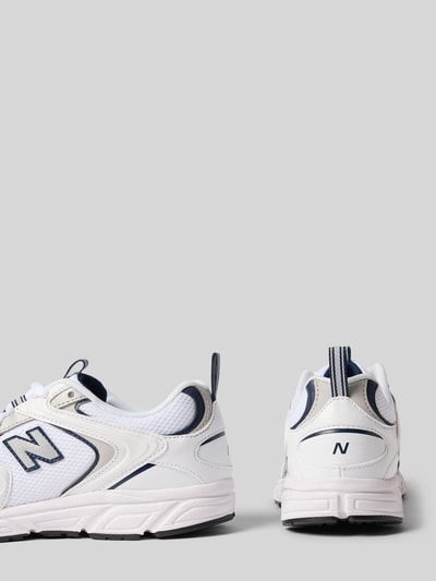 Produktfoto, Sneaker mit Logo-Detail Modell '408' von New Balance in Weiß mit blauen Akzenten, leicht profilierte Sohle, abgerundete Passform, Kontext: Damen Sneaker, Absatzhöhe 3 cm, Schafthöhe 7 cm, Schaftweite 8 cm.