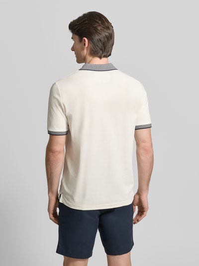 Männermodel trägt Modern Fit Poloshirt mit Stitching von Fynch-Hatton in Beige mit grauem Polokragen aus reiner Baumwolle, Ganzkörperansicht Rückansicht.