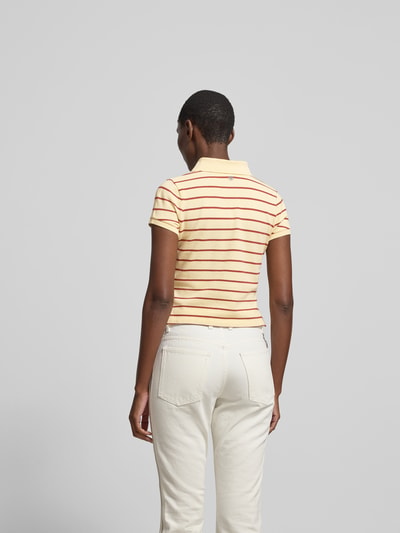 Frauenmodel trägt Cropped Poloshirt aus reiner Baumwolle von Rabanne, gestreift, Polokragen, kurzärmelig, verlängerte Rückseite, Rückenlänge 47 cm, Ganzkörperansicht Rückansicht.