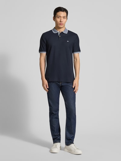 Męski model nosi Modern Fit Poloshirt mit Stitching von Fynch-Hatton z czystej bawełny, kołnierzyk polo, listwa guzikowa, ciemnogranatowy, tekstura gładka, długość pleców w rozmiarze M: 65 cm, całopostaciowy widok z przodu.