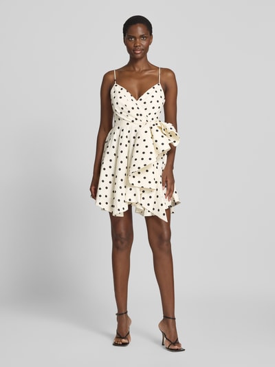 Frauenmodel trägt Cocktailkleid in Wickel-Optik von Forever New mit Polka-Dots, tailliert, reine Baumwolle, Minilänge, Ganzkörperansicht von vorne.