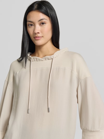 Frauenmodel trägt Relaxed Fit Sweatshirt mit Tunnelzug von Marc Cain in Beige, Stehkragen, elastische Ärmelabschlüsse, Halbarm, Nahaufnahme Oberkörper. Rückenlänge bei Größe 36: 57 cm.