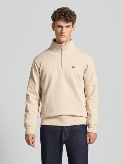 Männermodel trägt Regular Fit Troyer mit Label-Detail von Levi's®, Reine Baumwolle, Troyer-Kragen, Reißverschluss, Gerippte Abschlüsse, Ganzkörperansicht von vorne.