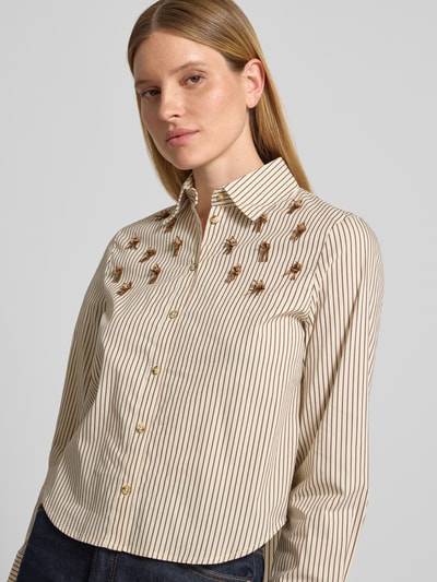 Kobiece modelka ma na sobie Regular Fit Bluse im Allover-Look mit Perlen od Christian Berg Woman Selection, mieszanka bawełny z dodatkiem streczu, wzór na całej powierzchni, perły, cekiny, kołnierzyk koszulowy, listwa guzikowa, długość tyłu w rozmiarze 36: 59 cm, długość rękawa w rozmiarze 36: 61 cm, całość w jasnych i ciemnych odcieniach z delikatną fakturą, zbliżenie na górną część ciała, widok z przodu.