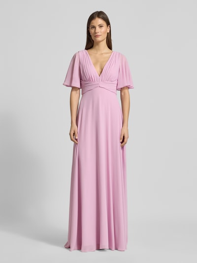 Kobiece modelka nosi Sukienka wieczorowa Regular Fit Abendkleid mit V-Ausschnitt von Jake*s Cocktail z szyfonu, dekolt w serek, krój regular fit, plisy, rękaw o dł. 1/2, dekolt na plecach, wszyty zamek błyskawiczny, halka pod spódnicę, długość tyłu w rozmiarze 36: 126 cm, szerokość w rozmiarze 36: 40 cm, długość rękawów w rozmiarze 36: 29 cm, pastelowy róż, gładka faktura, cała sylwetka z przodu