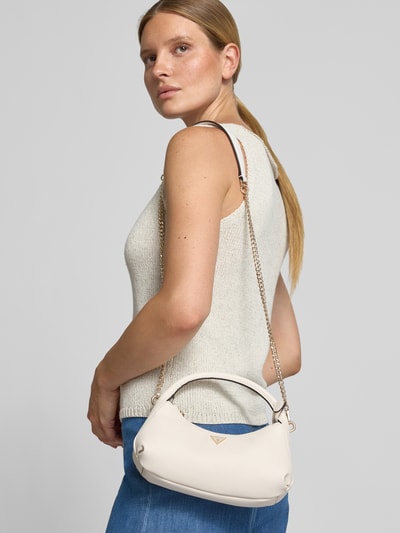 Frauenmodel trägt Mini Hobo Bag in Leder-Optik Modell 'GILDA' von GUESS in Creme mit Strukturmuster und Markenapplikation, Ganzkörperansicht Rückansicht.