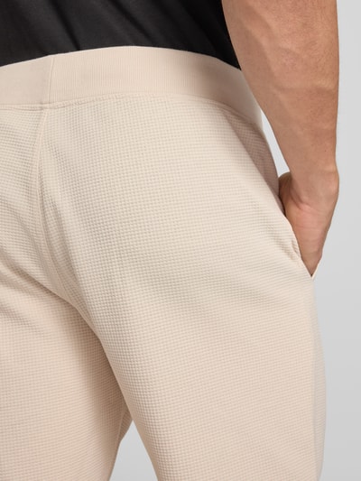 Männermodel trägt Straight Fit Shorts mit Strukturmuster von G-Star Raw im Elastischer-Material-Mix mit Logo-Detail, Detailaufnahme Rückansicht.