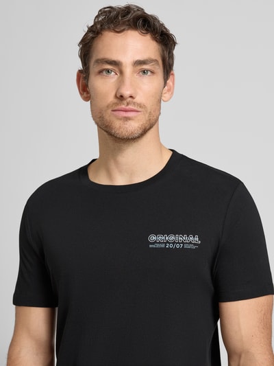 Männermodel trägt Regular Fit T-Shirt aus reiner Baumwolle von Tom Tailor Denim, unifarben mit Label-Schriftzug, Nahaufnahme Oberkörper.