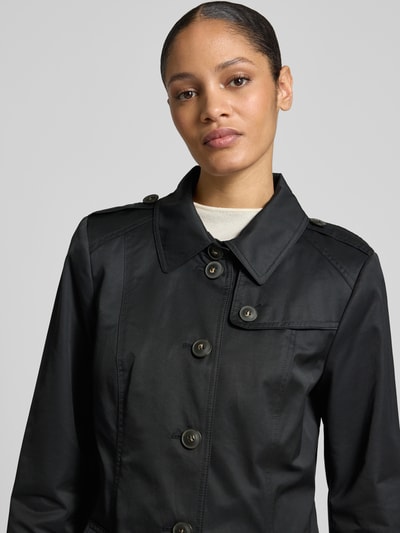 Frauenmodel trägt Trenchcoat mit Ärmelriegeln von Fuchs Schmitt in Schwarz, Regular Fit, Umlegekragen, Knopfleiste, Nahaufnahme Oberkörper