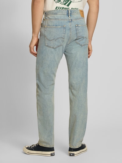 Männermodel trägt Relaxed Fit Jeans im Used-Look Modell 'CHRIS' von Jack & Jones, helle blaue Baumwolle, grobe Textur, Ganzkörperansicht Rückansicht. Bundweite 43 cm, Innenbeinlänge 77 cm bei Größe 32/34.