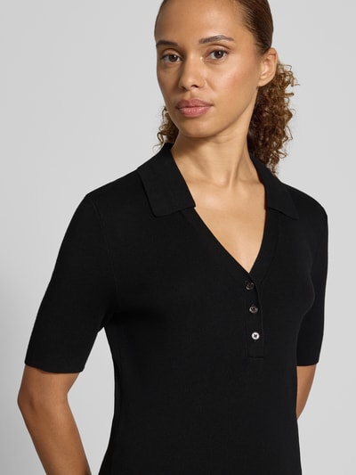 Kobiece modelka nosi czarną koszulkę polo Regular Fit Poloshirt aus Viskose-Mix von Jake*s Collection, zbliżenie na górną część ciała.