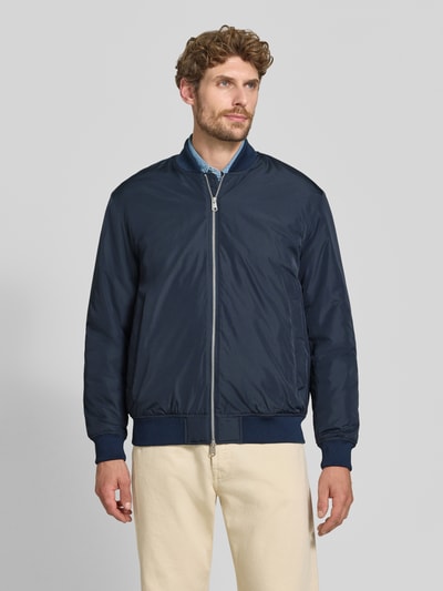 Männermodel trägt Regular Fit Bomberjacke mit Baseball-Kragen Modell 'CHARLES' von Selected, dunkelblau, glatte Textur, Ganzkörperansicht von vorne.