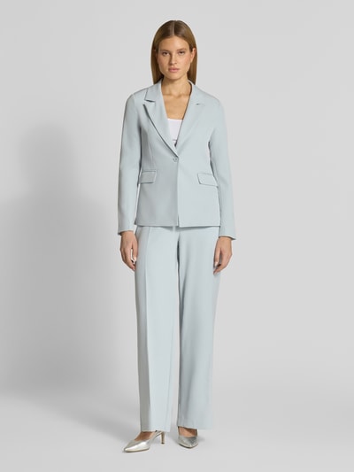 Frauenmodel trägt Regular Fit Blazer mit Pattentaschen Modell 'ISA' von GUIDO MARIA KRETSCHMER WOMAN in Hellblau, Ganzkörperansicht von vorne.