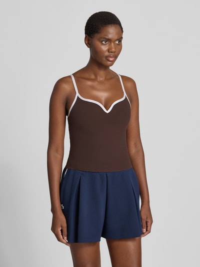 Frauenmodel trägt Trägertop mit Kontraststreifen Modell 'Sense Contour' von aim'n, braun mit V-Ausschnitt, körpernah, Nahaufnahme Oberkörper.