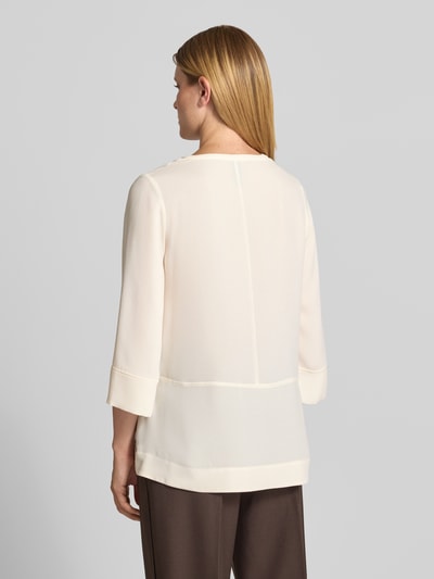 Modelka kobieca nosi Regular Fit Bluse mit V-Ausschnitt und 3/4-Arm von Marc Cain; kremowa bluzka, szwy działowe, rękaw o dł. 3/4, Długość tyłu w rozmiarze 36: 71 cm, Długość rękawów w rozmiarze 36: 51 cm, widok całej sylwetki z tyłu.
