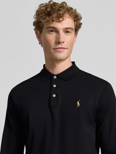 Männermodel trägt slim fit poloshirt aus puur katoen von Polo Ralph Lauren in zwart, merklogo op borst, nahaufnahme oberkörper.