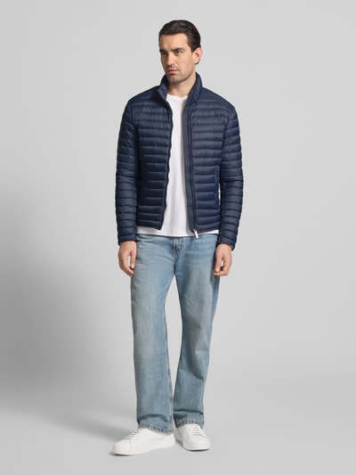 Männermodel trägt Steppjacke mit Zweiwege-Reißverschluss von Colmar Originals in Dunkelblau, Regular Fit, Stehkragen, Ganzkörperansicht von vorne. Rückenlänge 65 cm, Schulterbreite 47 cm, Brustweite 43 cm, Ärmellänge 67 cm, mit Eingrifftaschen.