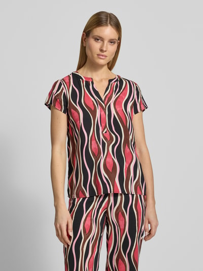 Vrouwenmodel draagt Regular Fit T-shirt uit zuiver viscose model 'Cammi' van Soyaconcept met tuniekhals, ruglengte maat S 69 cm, mouwlengte 15 cm, kleurrijk golvend patroon, vooraanzicht, close-up bovenlichaam.