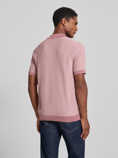 Męski model nosi koszulkę polo Slim Fit Poloshirt mit Strukturmuster model 'Brianoro' von JOOP! COLLECTION z bawełny, strukturalny wzór, listwa guzikowa, detal z logo, długość tyłu w rozmiarze M: 70 cm, jasnoróżowa, proste rękawy, fakturowana powierzchnia, Ganzkörperansicht Rückansicht.