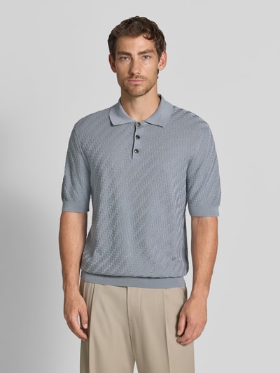 Mężczyzna nosi Regular Fit Poloshirt aus reiner Baumwolle in Strick-Optik von Matinique, imitacja dzianiny, bawełna, krój regular fit, kołnierzyk polo, z krótkim rękawem, długość tyłu w rozmiarze M 70 cm, jasnoszary, tekstura w drobny wzór. Ganzkörperansicht von vorne.