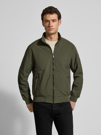 Männermodel trägt olivgrüne Regular Fit Jacke mit Stehkragen von Lerros, Reißverschluss, Logo-Detail, Eingrifftaschen, Ganzkörperansicht von vorne.