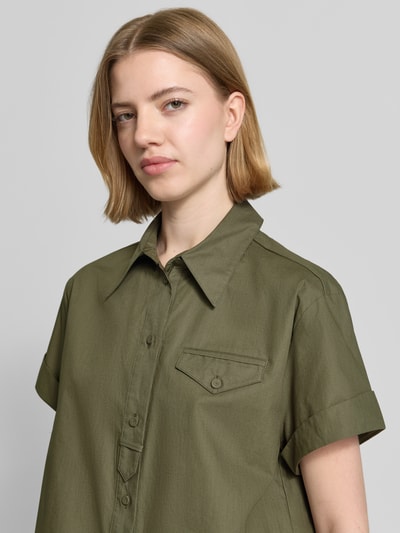 Frauenmodel trägt Boxy Fit Bluse mit Brusttasche von Luisa Cerano in Khaki, reine Baumwolle, Hemdblusenkragen, Nahaufnahme Oberkörper.