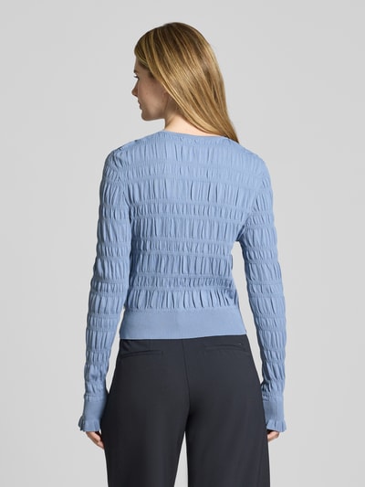 Frauenmodel trägt Cardigan mit Smok-Details und Rundhalsausschnitt von Scotch & Soda, Slim-Fit, Rückenlänge 50 cm, Rückansicht Ganzkörperansicht.