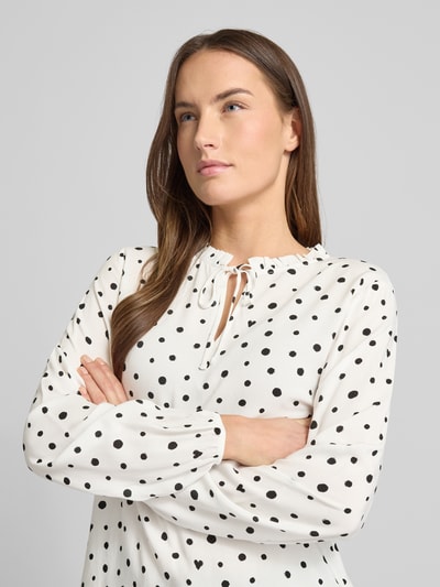 Frauenmodel trägt Regular Fit Langarmbluse aus reiner Viskose von Tom Tailor Denim, Optik: Unifarben, Muster: Gepunktet, Label-Stitching-Applikation, Rüschenkragen, Schlüsselloch-Ausschnitt, Knebelverschluss, Ärmelabschluss elastisch, Material: Viskose, Nahaufnahme Oberkörper.