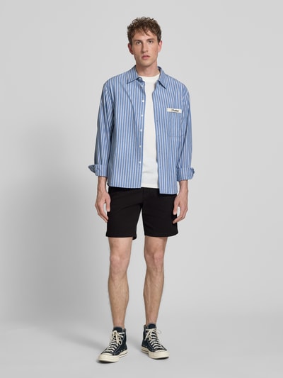 Männermodel trägt Straight Fit Shorts mit abnehmbarem Gürtel Modell 'Adam' von Jack & Jones in Schwarz, Baumwoll-Mix, Ganzkörperansicht von vorne.
