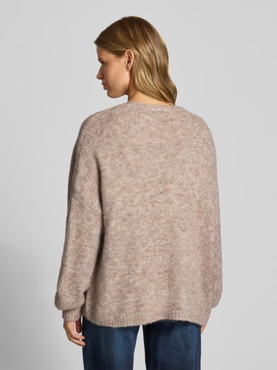 Frauenmodel trägt Regular Fit Strickjacke mit Woll-Anteil Modell 'NELLIE' von ONLY, beige meliert, strukturierte Oberfläche, Ganzkörperansicht Rückansicht, Damen Strickjacke von ONLY.