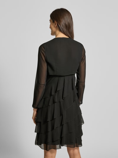 Männermodel trägt semitransparenten Bolero aus Chiffon von Swing, czarny, lekki, płynący materiał, długość pleców 32 cm, zdjęcie całopostaciowe z tyłu.