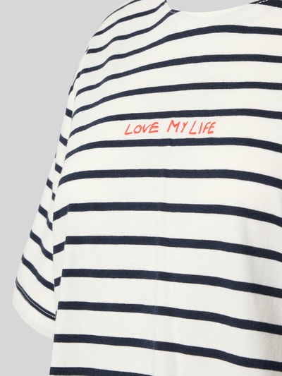 Frauenmodel trägt Relaxed Fit Pyjama-Oberteil mit Statement-Stitching von [Marke], reine Baumwolle, Streifenmuster, Rundhalsausschnitt, kurzärmelig, Nahaufnahme Oberkörper.