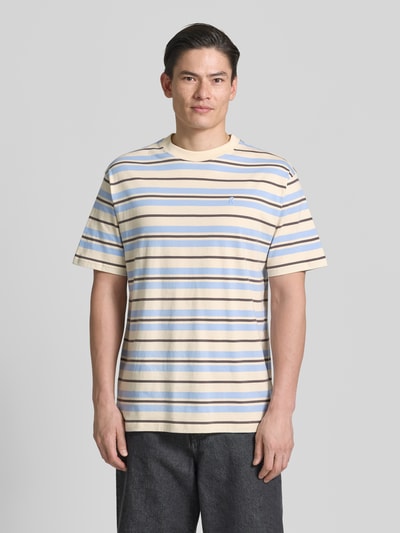 Männermodel trägt Relaxed Fit T-Shirt aus reiner Baumwolle Modell 'MAARKOS' von Armedangels, mehrfarbig, gestreift, Ganzkörperansicht von vorne.
