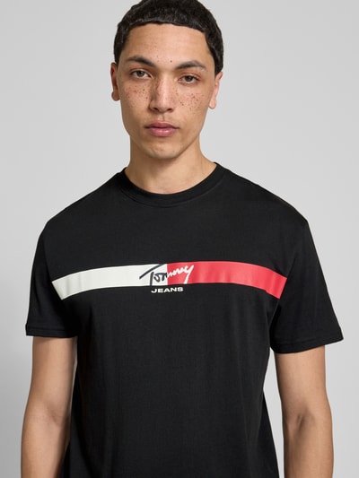 Männermodel trägt Regular Fit T-Shirt aus reiner Baumwolle von Tommy Jeans, Optik: Unifarben, Label-Print, Nahaufnahme Oberkörper