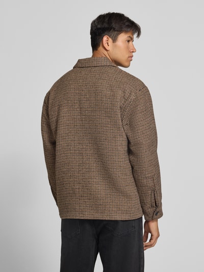 Männermodel trägt Regular Fit Hemdjacke mit Brusttasche Modell 'SOHO OLLIE' von JACK & JONES, braun kariert, Ganzkörperansicht Rückansicht.