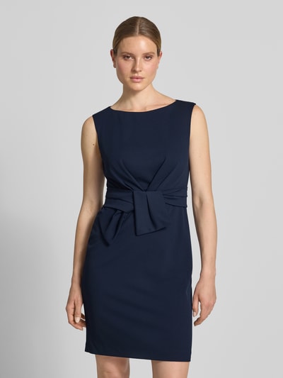 Frauenmodel trägt Knielanges Cocktailkleid mit Knotendetail von Vera Mont in Dunkelblau, Material-Mix mit Stretch-Anteil, Gerader-Schnitt, Rundhalsausschnitt, Knielänge, Nahaufnahme Oberkörper.