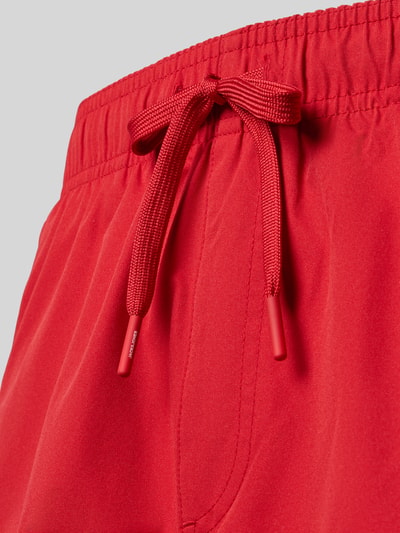 Produktfoto, Badehose mit Label-Stitching Modell 'MAUI' von Jack & Jones in leuchtendem Rot, elastischer Bund mit Tunnelzug, Regular Fit, Stoff mit glatter Textur.