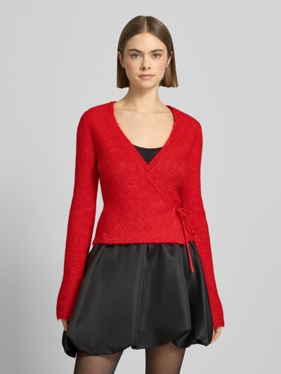 Frauenmodel trägt Cardigan in Wickel-Optik von Gina Tricot in Rot, Material-Mix mit Alpaka-Anteil, Slim-Fit, V-Ausschnitt; Nahaufnahme Oberkörper.